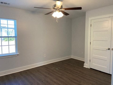 A room with a ceiling fan and a door.