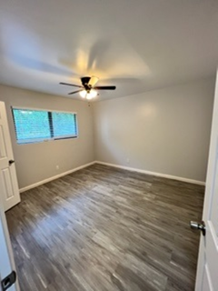 A room with a ceiling fan and a window.
