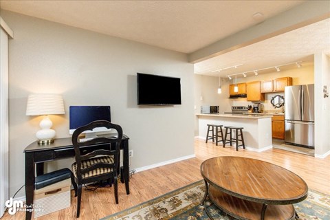 a living room and kitchen with a table and a tv
