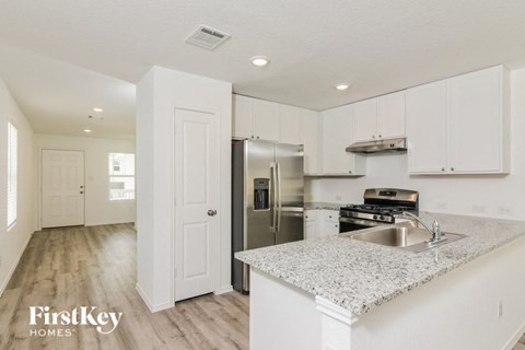 a kitchen with white cabinets and a granite counter top