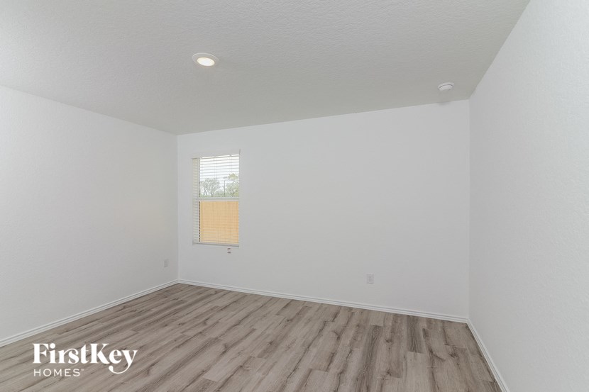 the living room of a house with white walls and wood floors
