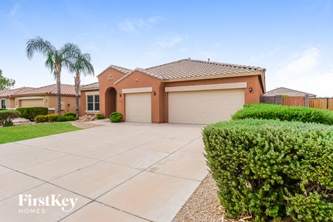 A house with a brown roof and tan garage door is for sale.