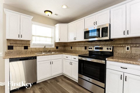 A kitchen with white cabinets and stainless steel appliances.