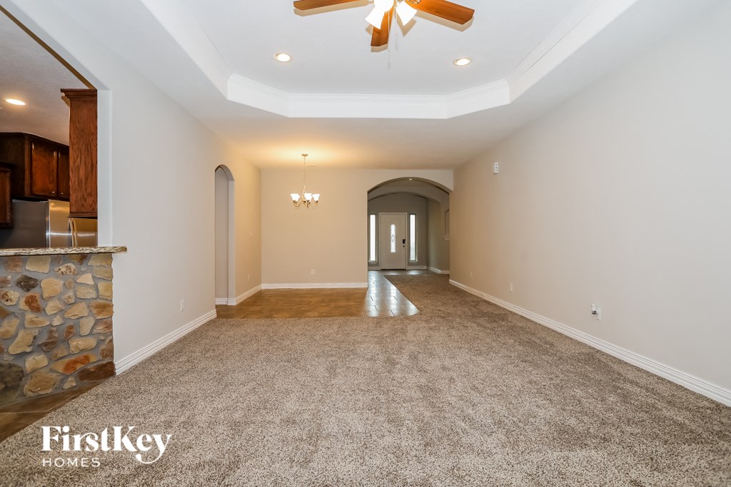 a living room with carpet and a ceiling fan