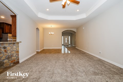 a living room with carpet and a ceiling fan