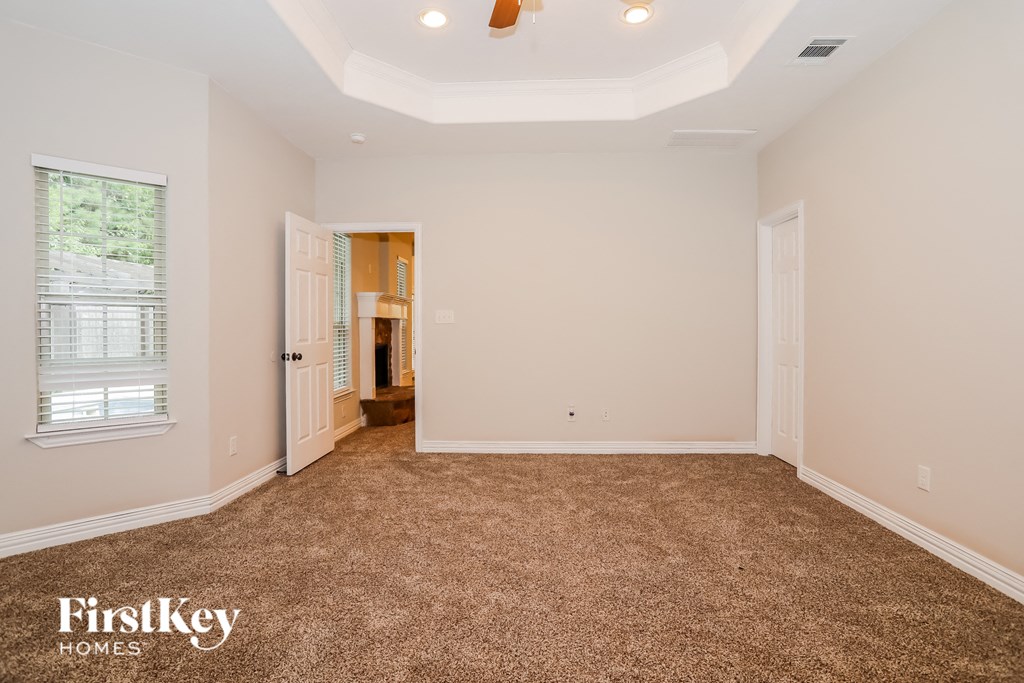 a bedroom with a carpeted floor and a door to a bathroom