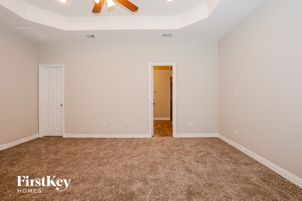 a empty room with carpet and a ceiling fan