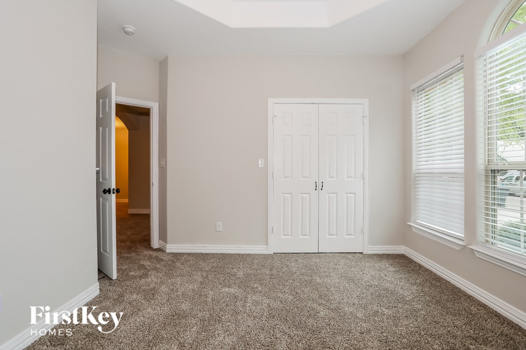 a bedroom with a white door and a carpeted floor