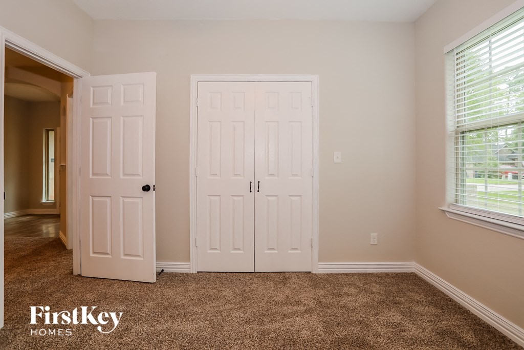 a bedroom with two white doors and a carpeted floor