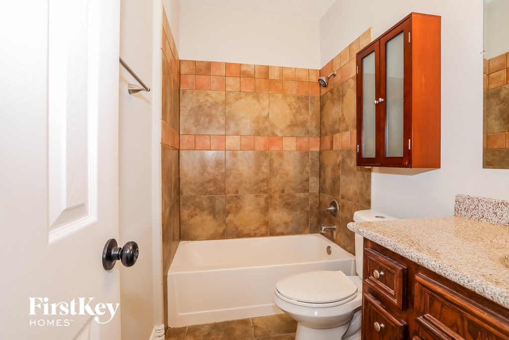 a bathroom with a toilet and a tub and a sink