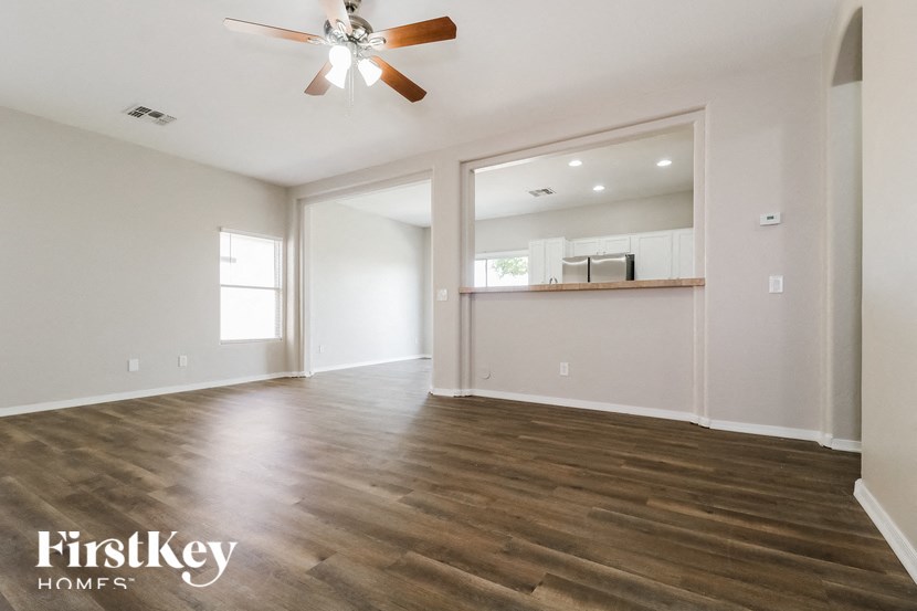 A spacious room with a ceiling fan and wooden flooring.