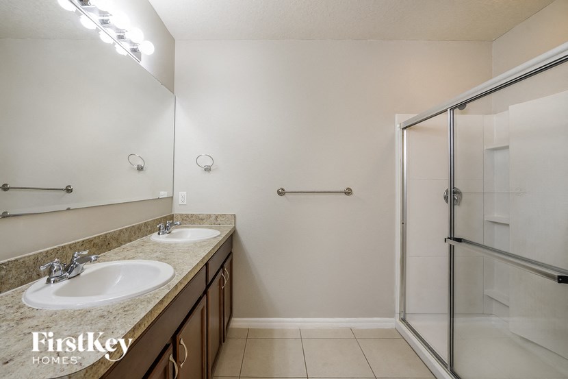 a bathroom with two sinks and a shower