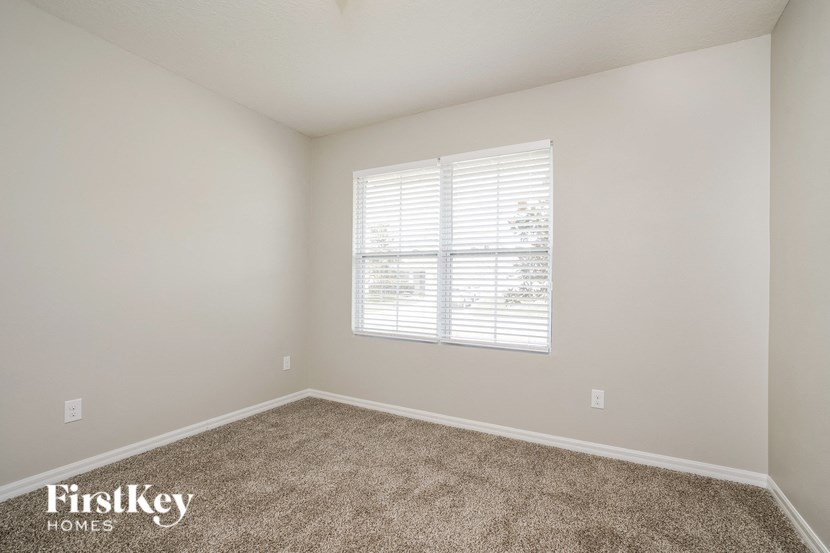 a spacious room with carpet and a window