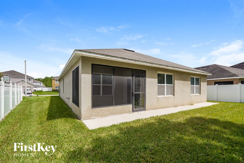 a small tan house with a yard and grass