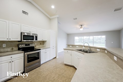 a large kitchen with white cabinets and stainless steel appliances