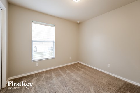 a spacious room with carpet and a window