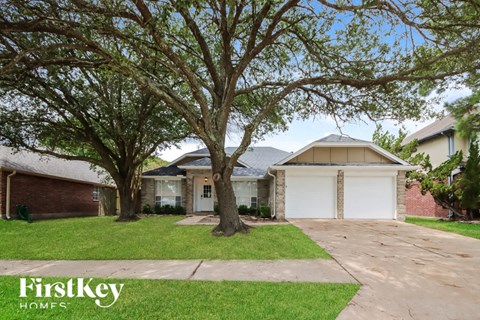 a house with a driveway and trees in front of it