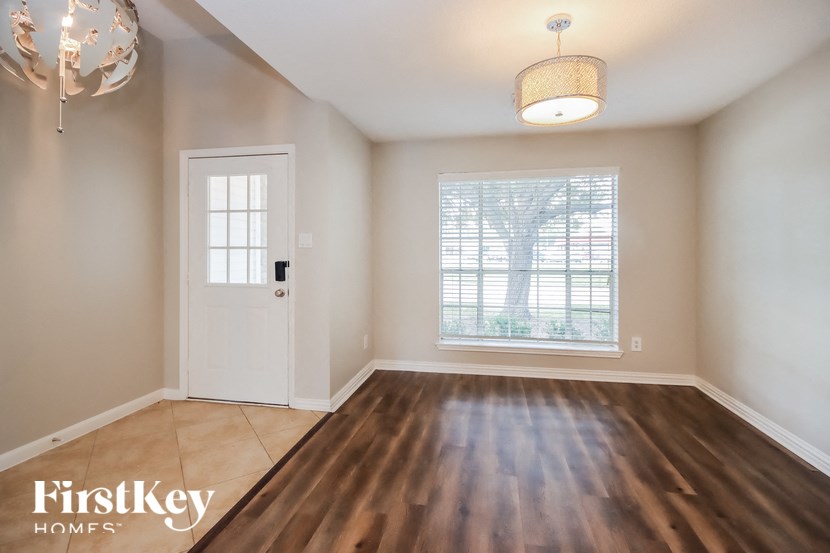 an empty living room with a window and a door to a tree
