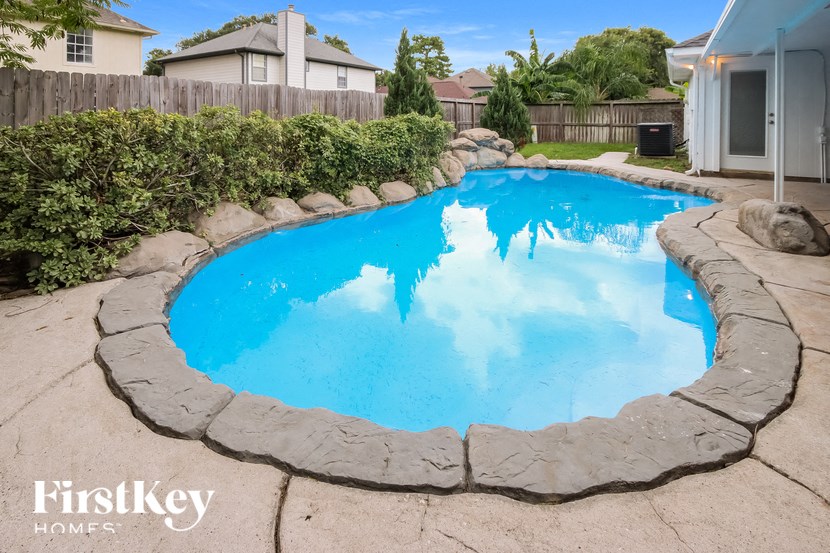 a large swimming pool in a backyard with a house