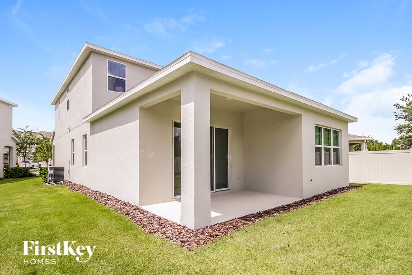 A modern house with a white exterior and a large front yard.