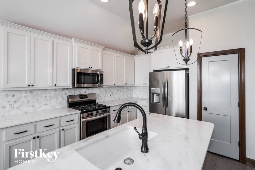 a kitchen with white cabinets and stainless steel appliances