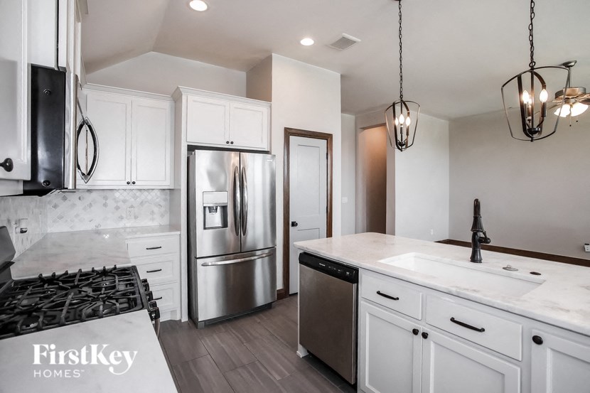 a kitchen with white cabinets and a stainless steel refrigerator