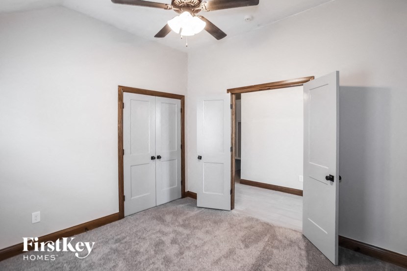 a bedroom with two doors and a ceiling fan