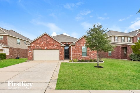A brick house with a garage door is for sale.