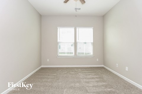 a bedroom with a carpeted floor and a window