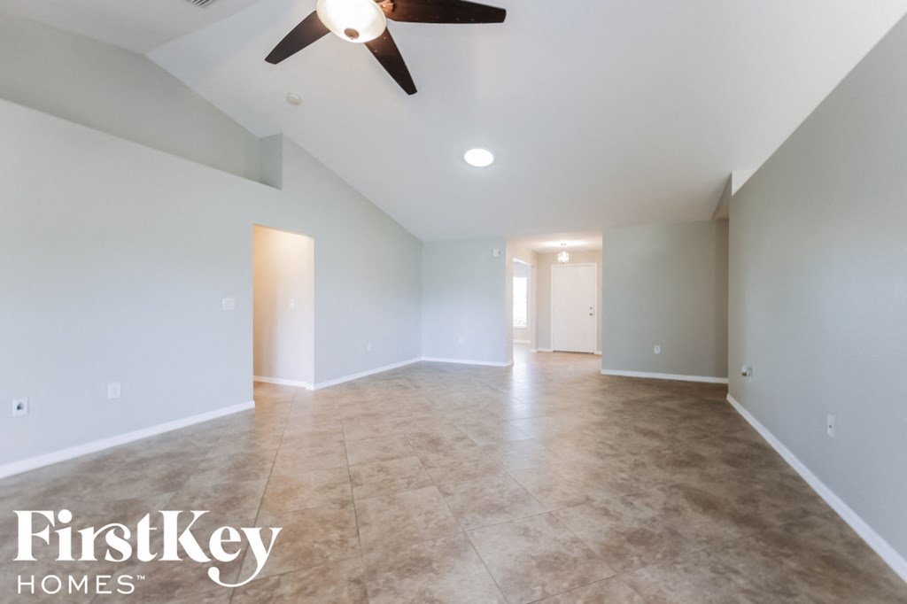 A spacious room with a ceiling fan and tiled floor.