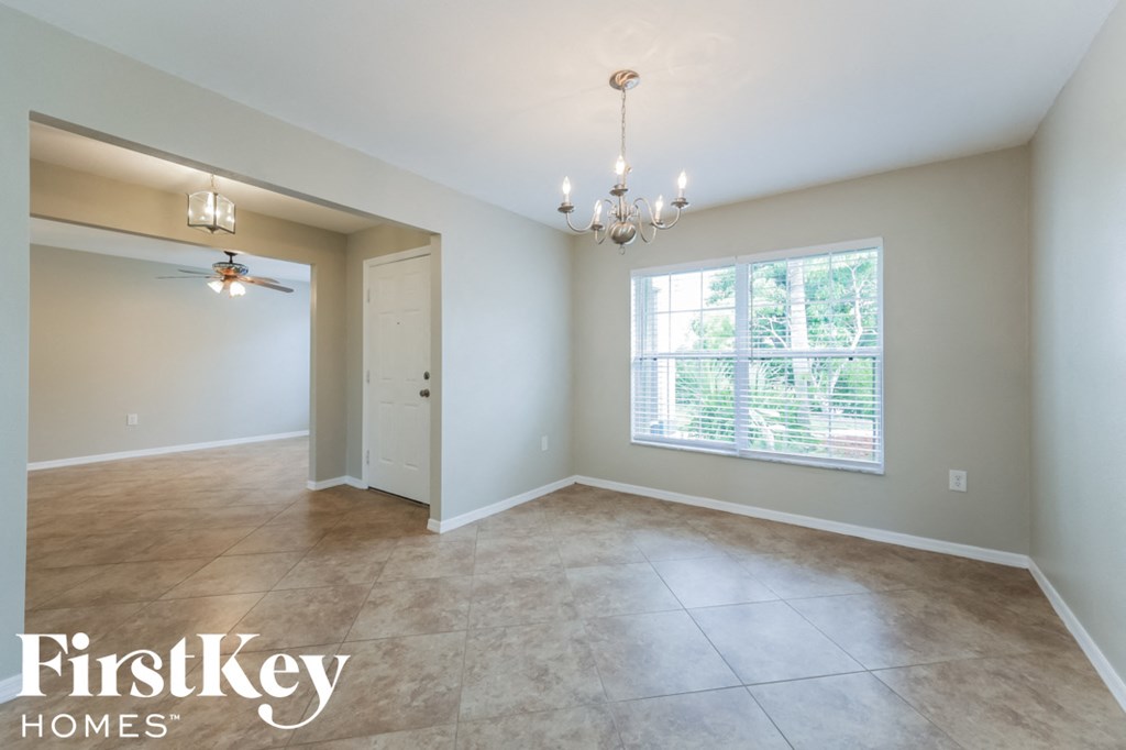 A spacious room with a chandelier and a ceiling fan.