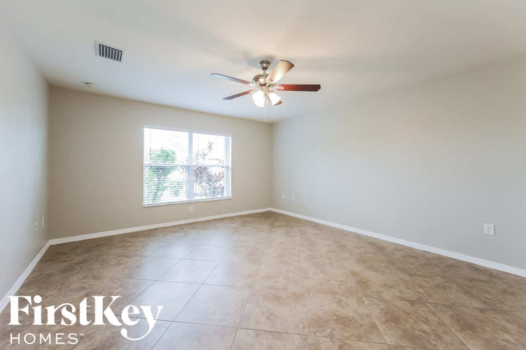 A room with a ceiling fan and a window.