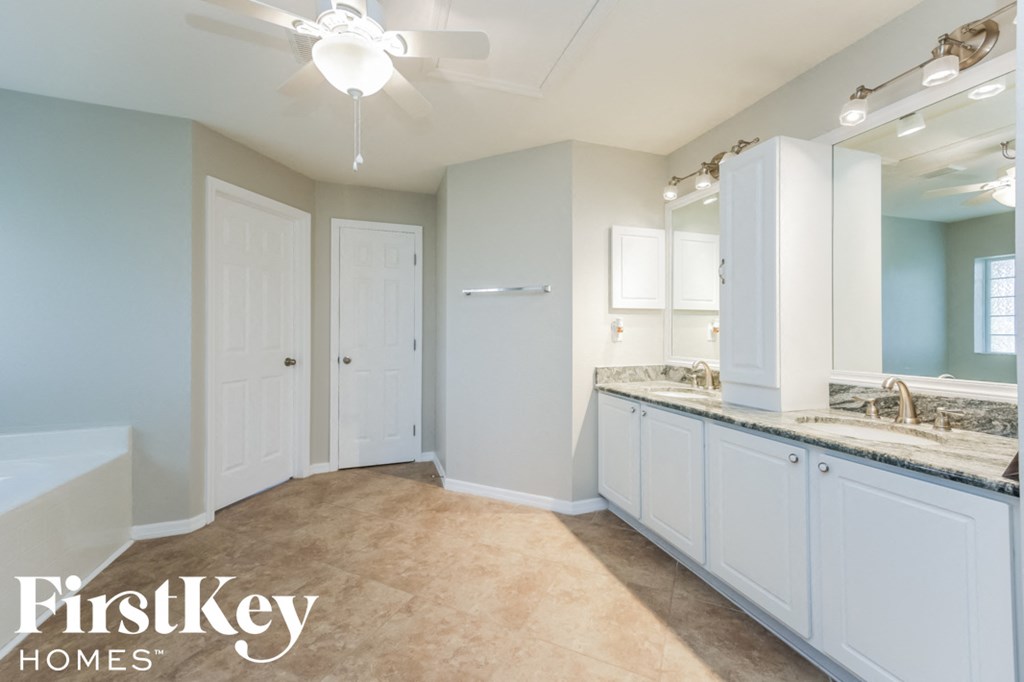 A bathroom with a fan and a mirror.