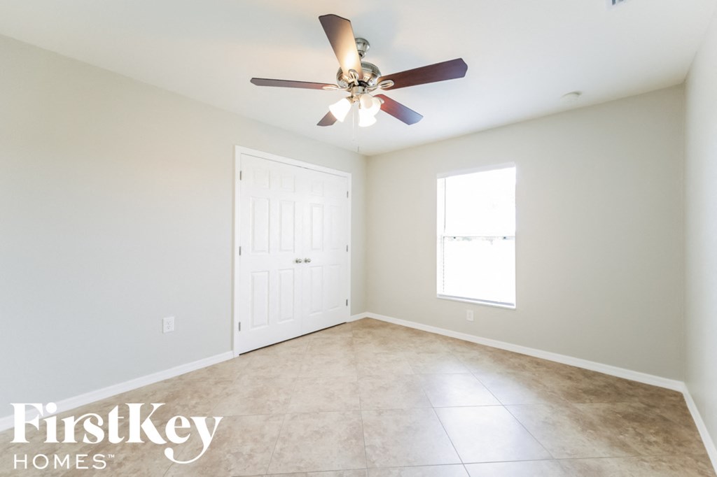 A room with a ceiling fan and a window.