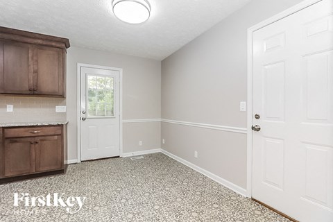 an empty kitchen with a white door and a window
