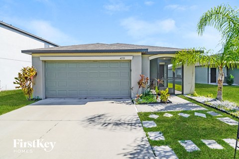 A house with a garage and a driveway in front of it.