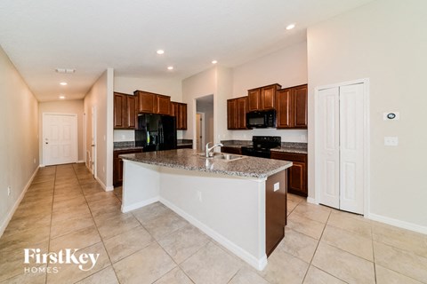 A kitchen with a white island and brown cabinets.