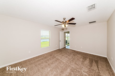 A spacious room with a ceiling fan and carpeted floor.