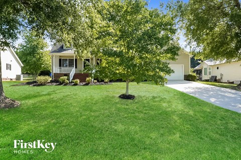 a yard with a tree in front of a house