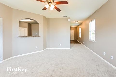 A spacious room with a ceiling fan and a mirror on the wall.