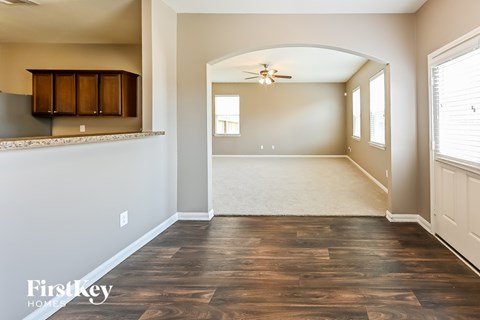 A spacious room with wooden flooring and a ceiling fan.