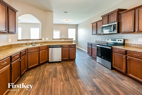 A kitchen with wooden cabinets and a stainless steel dishwasher.