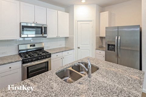 A kitchen with granite countertops and stainless steel appliances.
