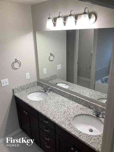 a bathroom with two sinks and a mirror