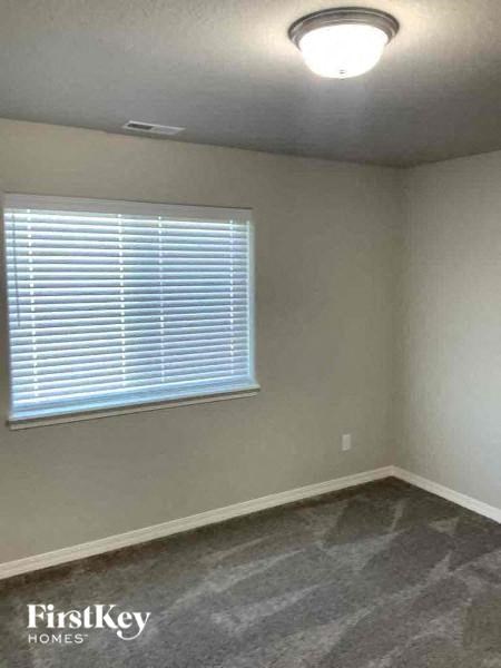 an empty room with a window and a gray floor