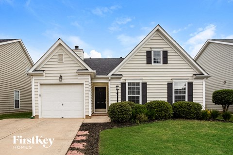 a white house with a white garage door and a lawn