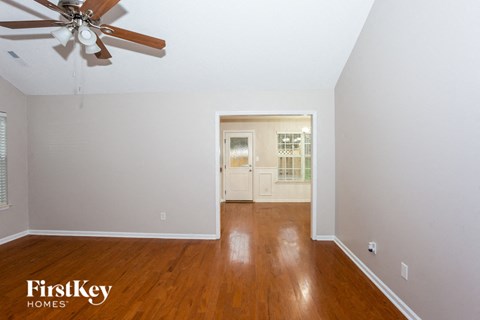 a living room with wood floors and a ceiling fan