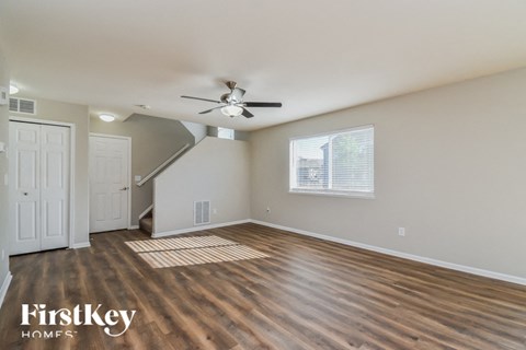 the living room with hardwood floors and a ceiling fan