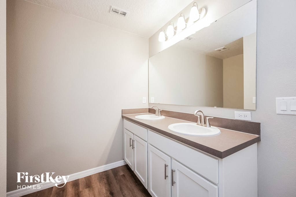the interior of a bathroom with two sinks and a mirror