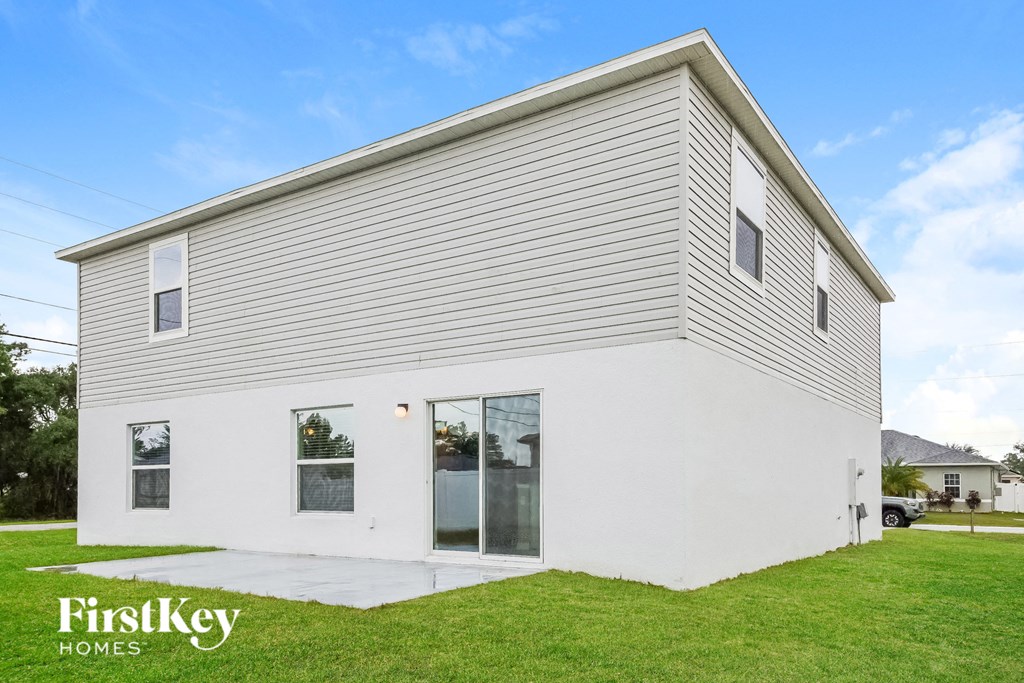 the exterior of a white house and a green lawn